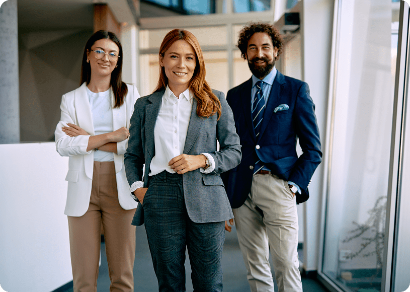 Three professionals smiling in office setting.