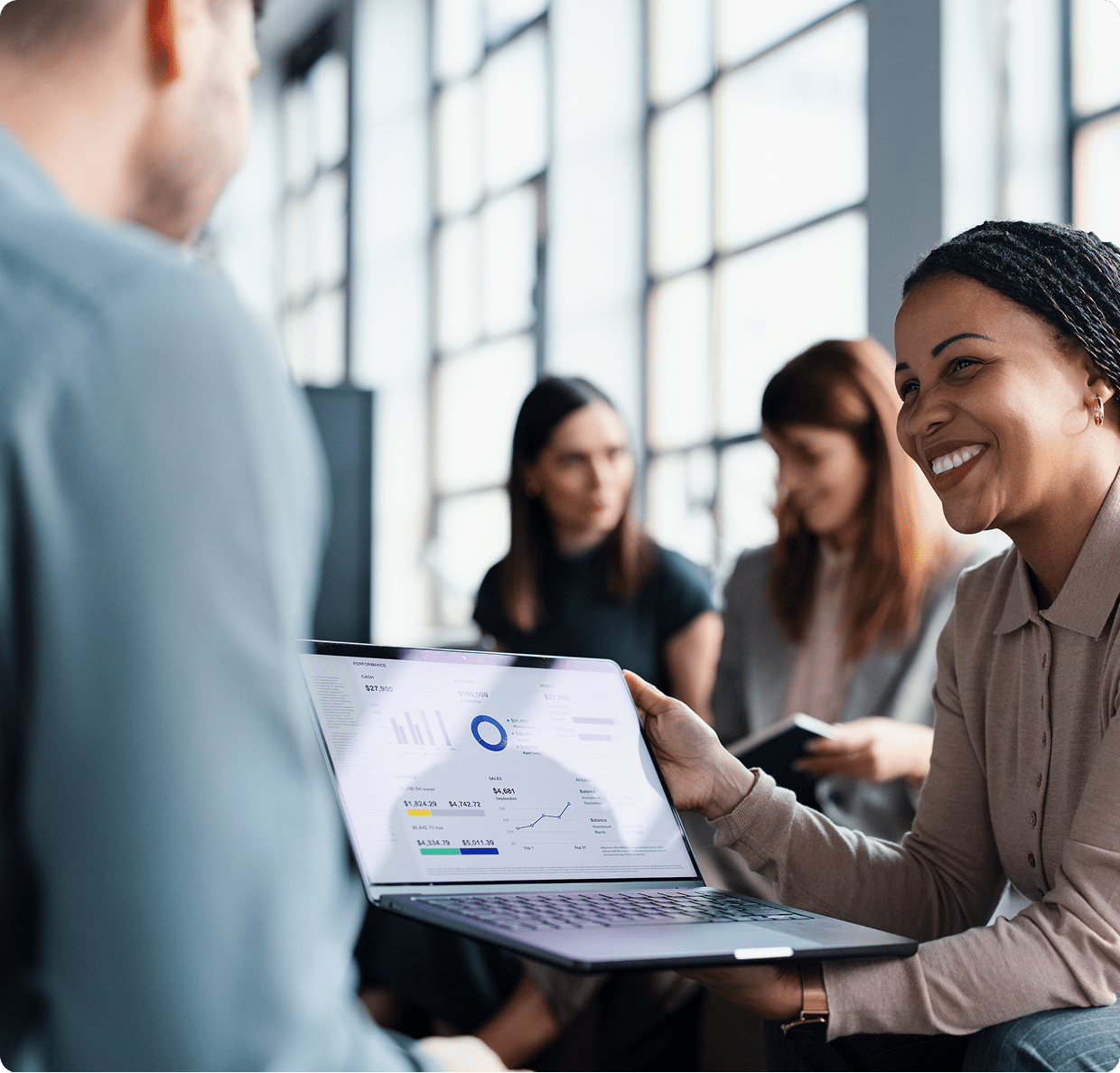 People discussing data on a laptop screen.