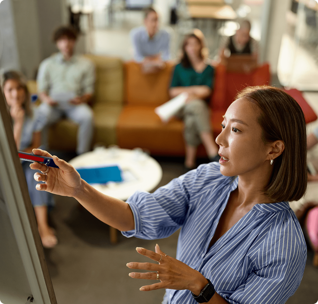 Woman presenting in front of attentive audience.