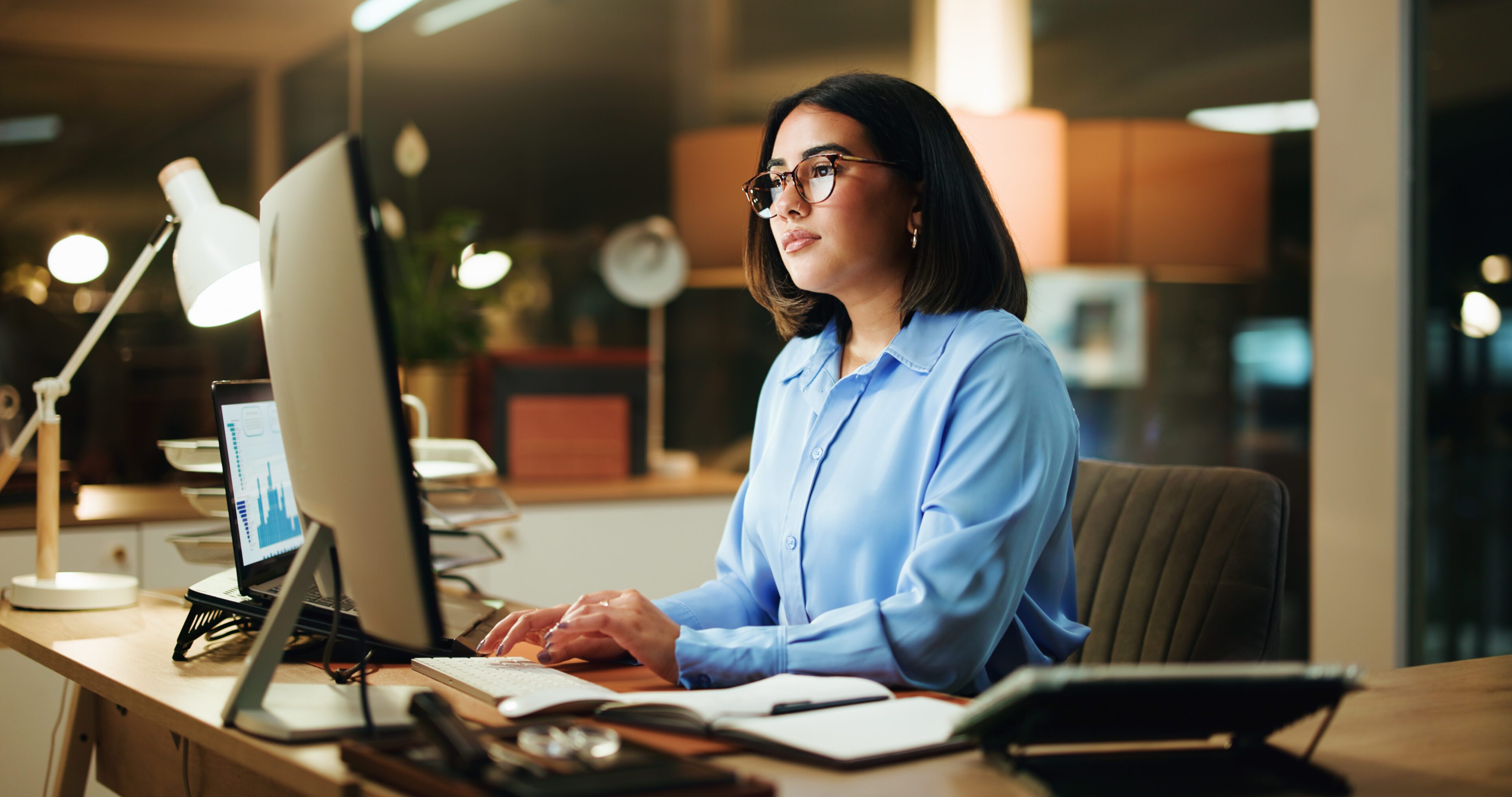 Night, reading and business woman with computer for stock market analysis, chart or financial review. Desktop, deadline or serious broker in office for trading, investment forecast or portfolio stats